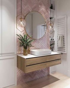 a bathroom with a sink, mirror and plant on the counter in front of it