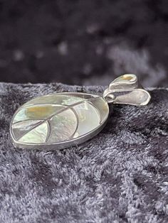 15% off Holidays Sale This vintage 950 fine silver pendant is a unique boho style piece that is sure to catch the eye. The pendant is in the shape of a leaf and features a stunning mother of pearl/abalone main stone in a range of beautiful multicolor hues. Crafted with sterling silver, this pendant is of the highest quality with a metal purity of 950. The pendant is perfect for those who love nature and beauty, as well as those who are inspired by bohemian style. This piece is in excellent condition and is sure to be a treasured addition to any jewelry collection. Dimensions: 2.5 inches high, 1.75 inches wide, .25 inches thick. In excellent condition. Thank You, Kevin Bohemian Silver Jewelry With Mother Of Pearl, Traditional Silver Mother Of Pearl Jewelry, Leaf Pendant, Abalone Shell, Fine Silver, Boho Style, Bohemian Style, Mother Of Pearl, Silver Pendant