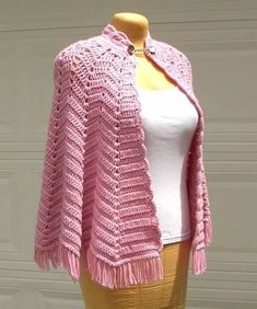 a pink crocheted shawl on a mannequin