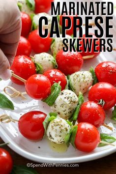 tomatoes and mozzarella covered caprese skewers on a white plate