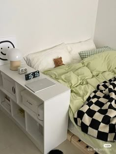 a bedroom with a bed, nightstand and clock