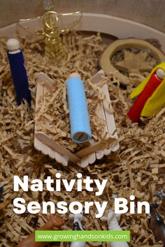 A DIY Nativity sensory bin featuring wooden peg figures dressed in felt to represent Mary, Joseph, and baby Jesus in a manger. The bin is filled with shredded paper to resemble hay, along with simple props like a gold pipe cleaner angel and animal figurines, creating a hands-on Christmas activity for kids. Sensory Bin For Toddlers, Nativity Activity, Christmas Units, Diy Nativity, Christmas Teaching, Advent Activities, The Nativity Story, Toddler Sensory, Advent Season