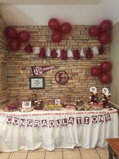 the table is set up with balloons and congratulationss on it for someone's graduation party