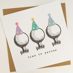 three golf balls with party hats on them sitting in front of a card that says time to party