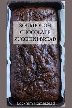 a loaf of chocolate zucchini bread in a pan with the words sourdough chocolate zucchini bread