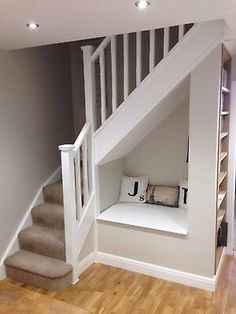 an empty room with stairs and white furniture