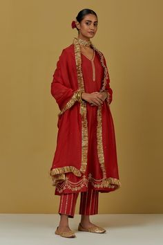 Red kurta with floral embroidery and V neck. Paired with sequin work pant and tissue organza fringe dupatta.
Components:3
Pattern:Embroidered
Type of Work:Floral
Neckline:V Neck
Sleeve Type:Flared
Fabric:Chanderi Silk, Tissue Organza
Color:Red
Other Details:
Floral and sequin work
Occasion:Puja - Aza Fashions The Loom Suits, Red Silk Suit, Red Dress Indian, Red Suits, V Neck Kurta, Punjabi Suits Party Wear, Red Kurti, Classic Suits, Chanderi Silk Suits