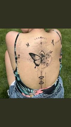 the back of a woman's body with tattoos on it and butterflies flying around