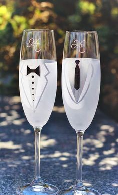 two wine glasses with the names p2 topper on them, sitting next to each other