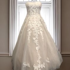 a white wedding dress on display in front of a window