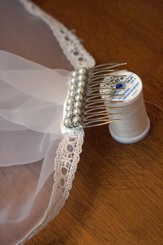 a close up of a hair comb on top of a piece of cloth and thread