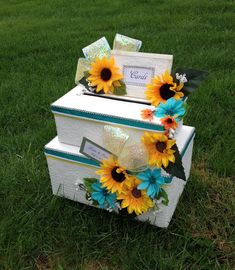 two boxes with sunflowers on them sitting in the grass