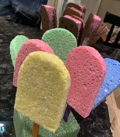 colorful popsicles are sitting on top of each other in front of a countertop