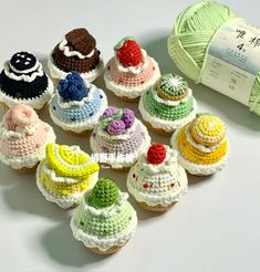 small crocheted cupcakes are next to a ball of yarn