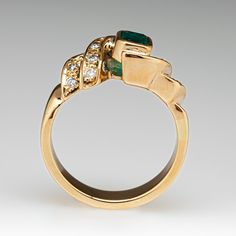 a gold ring with an emerald and diamonds