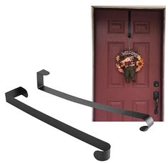 two black metal towel racks next to a red door with a fall wreath on it