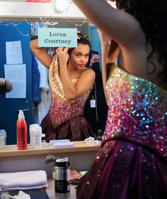 a woman standing in front of a mirror holding up a sign that reads lorna coutley