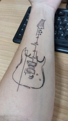 a person with a guitar tattoo on their arm