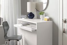 a white desk with a mirror, lamp and chair