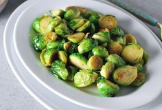 a white plate topped with brussel sprouts on top of a table