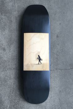 a skateboard that is laying on the ground with a person walking in front of it