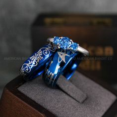 two rings with blue and white designs on them sitting on top of a wooden stand