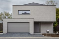 a white brick house with two garage doors