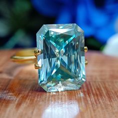 Big Radiant Colored Moissanite Engagement Ring, 20 CT Blueish Green Moissanite Solitaire Bridal Wedding Ring, Huge Women Promise Ring, Gifts for Her, Anniversary Ring, Birthday Sale, Solid Gold Moissanite Diamond Jewelry, Dainty Cocktail Ring ✶ 𝐒𝐭𝐨𝐧𝐞 𝐒𝐢𝐳𝐞 (𝐀𝐩𝐩𝐫𝐨𝐱.) - 20 CT = 18x14 mm - 15 CT = 16x12 mm - 10 CT = 14x11 mm ✶ 𝐏𝐫𝐨𝐝𝐮𝐜𝐭 𝐈𝐧𝐟𝐨𝐫𝐦𝐚𝐭𝐢𝐨𝐧 ➙ Stone Type: Moissanite ➙ Stone Shape: Radiant Cut ➙ Stone Color: Blue-Green ➙ Stone Clarity: VVS ➙ Stone Make: High Qual Radiant Moissanite Engagement Ring, Colored Moissanite, Engagement Rings Cushion Solitaire, Radiant Engagement, Radiant Moissanite, Green Moissanite, Blueish Green, Birthday Sale, Radiant Engagement Rings