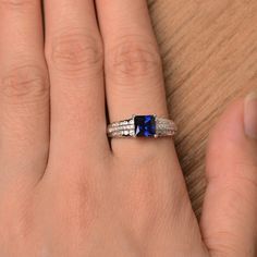 It is a lab sapphire ring. The main stone is 6 mm*6 mm princess cut.weight about 1.37 carats. The basic metal is sterling silver and plated with rhodium. To change the metal to a solid gold (white/rose) or platinum is also available, please ask for a quotation if you want. You can also go to my shop Home for more elegant rings: https://www.etsy.com/shop/godjewelry?ref=hdr_shop_menu Sapphire is the September birthstone. More sapphire rings: https://www.etsy.com/shop/godjewelry?section_id=20715031 Silver Sapphire Ring With Center Stone In Princess Cut, Silver Sapphire Solitaire Ring Princess Cut, Silver Princess Cut Sapphire Ring For Gift, Blue Princess Cut Sapphire Ring Gift, Fine Jewelry Sapphire Ring In Sterling Silver, Princess Cut, Tanzanite Diamond Ring, Tanzanite Diamond, Ring Ring, Party Rings