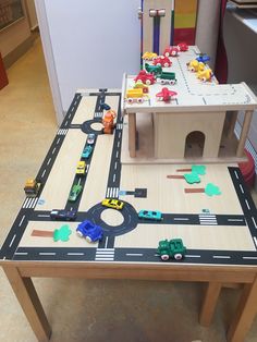 a toy table with cars and trucks on it