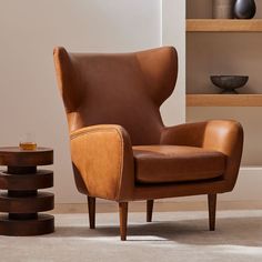 a brown leather chair sitting on top of a white rug