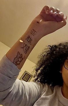 a woman is holding up her arm with writing on it