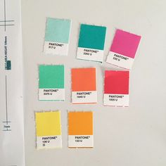 several different colors of paint on a white surface next to a ruler and some papers