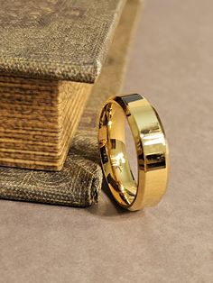 a gold wedding ring sitting on top of a book