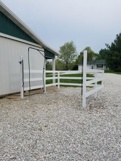 a white fenced in area next to a building