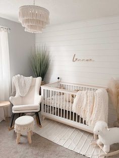 a baby's room with a crib, rocking chair and rugs on the floor