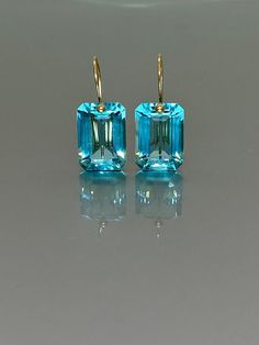 Gorgeous sparkly sky blue aquamarine earrings. The Faceted emerald cut drops are flawless and have a beautiful sky-blue color. The drops are attached to 24k gold vermeil/ 14K SOLID GOLD ear wires. The earrings are elegant and have a lux look.  A truly gorgeous pair of earrings. When 14K SOLID GOLD ear wires are being used, the ear wire ends are hand-stamped as proof of being 14K solid gold. In addition, extra work was done at the end of the ear wires to prevent any sort of pain or injury while i Chanel Stud Earrings, Red Garnet Earrings, Ruby Earrings Studs, Aquamarine Earrings, Topaz Jewelry, Blue Topaz Earrings, Aquamarine Jewelry, March Birthstone, Types Of Gemstones