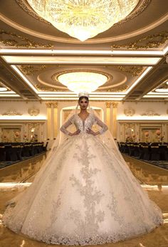 a woman in a white wedding gown standing on the floor with her hands on her hips