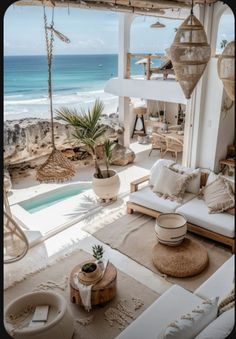 a living room filled with lots of furniture next to an ocean side pool and beach