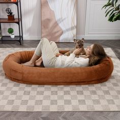 a woman laying in a dog bed on the floor