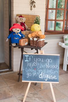 two teddy bears sitting on top of a table next to a chalkboard with writing