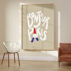 a living room with two chairs and a painting on the wall that says bonjou paris