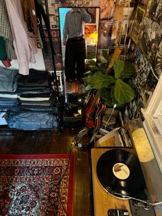 a record player sitting on top of a wooden table next to a plant and rug