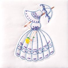 a white dress with blue trimming and an umbrella on the back is embroidered onto it