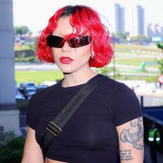 a woman with red hair and sunglasses on