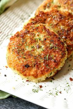 two crab cakes sitting on top of a white paper towel next to a green napkin