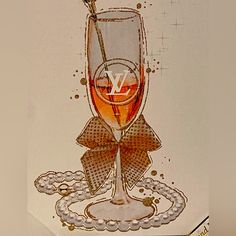 a glass of wine with a bow on the side and pearls around it, sitting on top of a table