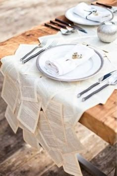 the table is set with silverware and napkins on it, along with other place settings