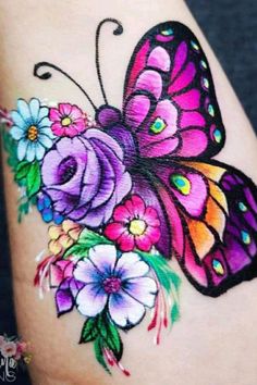 a colorful butterfly with flowers on it's arm