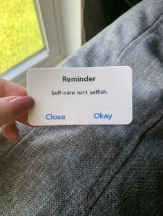 someone is holding up a business card that says, reminder self - care isn't selfish close okay